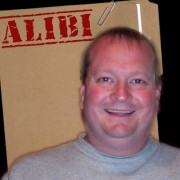 Smiling man with thinning hair in front of a manila folder stamped "Alibi"